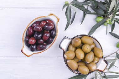 Geleneksel mezeler, Yunan mutfağından zeytinler. Beyaz ahşap arka plan. Yukarıdan bak. Taze zeytin dalları. Boşluğu kopyala.