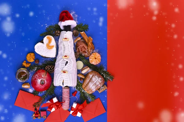 Різдвяне дерево зроблене з вина, сиру, просьютто і фруктів. Блакитний фон і червоний. Вид зверху. Концепція різдвяних та новорічних свят. Для листівок. Копіювальний простір — стокове фото