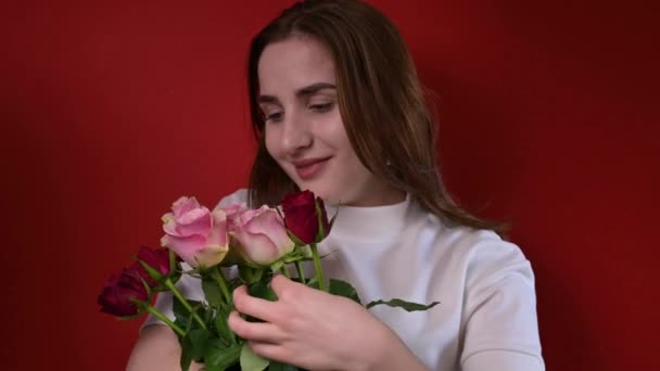Koncepcja Walentynek i Dni Kobiet. Szczęśliwa młoda dziewczyna trzyma bukiet róż. — Wideo stockowe