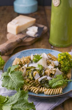Tahta bir masada parmesanlı bir tabakta Cime di rapa makarna. İtalya 'nın güneyindeki Puglia' dan geleneksel yiyecekler. Kırsal bir fotoğraf. Boşluğu kopyala