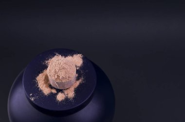 Siyah kasede bir kepçe çikolatalı süt proteini. Sağlıklı beslenme ve vitamin kavramı.