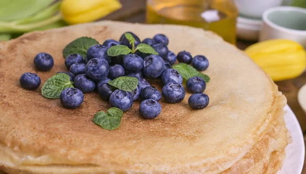 Pancake dengan blueberry dan madu di piring, di atap kayu. Pastri tradisional untuk festival Rusia Maslenitsa. ruang kosong untuk teks. Tembakan jarak dekat . — Stok Foto