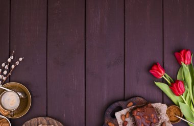 Tahta bir masada taze aromatik espresso ve browni. Bahar kahvaltısı, çiçekler, laleler, hamur işleri ve kahve. Üst Manzara. Metin için boş alan.