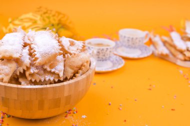 Crostoli, chiacchiere, bisküvi kurabiyeleri ve sarı arka planda kokulu espresso, konfeti ve şenlikli dekor ile renklendirilmiş. Geleneksel İtalyan karnavalı için kahve ve şeker. Boşluğu kopyala