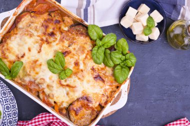 Fırında pişirilmiş geleneksel İtalyan mutfağı, mozzarella, parmesan, fesleğen ve sebzeli. Uzayı kopyala Yukarıda.