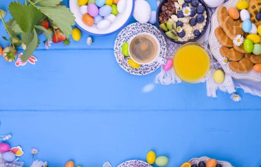 Paskalya kahvaltısı düzdü. Espresso kahvesi, reçelli pasta, kurabiyeler, taze portakal suyu, meyve, granola, yapraklı çilek ve böğürtlen. Paskalya Pazar 'ı için renkli yumurta. Uzayı kopyala Yatay