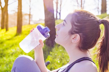 Koşudan sonra su içen kadın koşucular. Fitness, insanlar ve sağlıklı yaşam tarzı. Parkta spor sabahı. Renkli fotoğraf