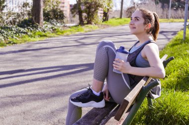 Koşudan sonra su içen kadın koşucular. Fitness, insanlar ve sağlıklı yaşam tarzı. Parkta spor sabahı.