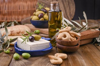 Zeytinli Yunan peyniri ve İtalyan krakeri ve İtalyan krakeri veya TARALLI. Taze zeytin dalları, şişede zeytinyağı ve geleneksel İtalyan atıştırmalıkları. Boşluğu kopyala