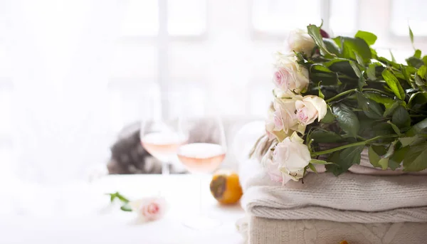 Rózsa csokor természetes fény. Virágok az ablaknál és két pohár rózsabor. Hangulatos és romantikus hangulat. Banner hosszú formátum. Másold a helyet. Szelektív fókusz eltért a tárgytól. — Stock Fotó