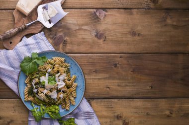 Tahta bir masada parmesanlı bir tabakta Cime di rapa makarna. İtalya 'nın güneyindeki Puglia' dan geleneksel yiyecekler. Rustik resim. 