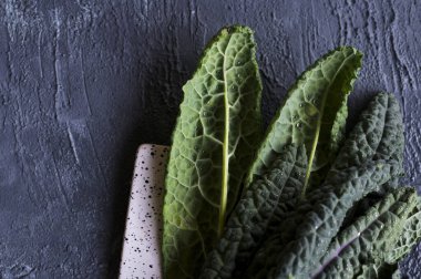 Bir demet kara lahana, İtalyan salatası, yeşil sebze izni, sağlıklı beslenme, vejetaryen yemeği. Süper yemek. Seçici odaklanma. Uzayı kopyala Yukarıda.