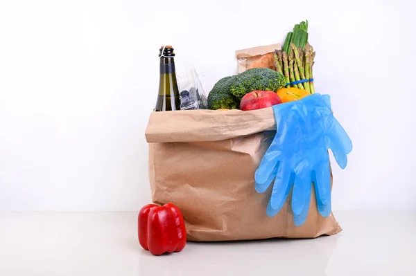 Set of food on a white background. Paper bag with Food supplies crisis food stock for quarantine isolation period. Food delivery, Donation, coronavirus.Fresh vegetables, fruits, olive oil. Soft focus.