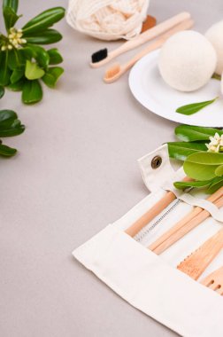 Eko kağıt sofra takımı. Yiyecek, pamuk torbası, diş fırçası, tabak, çatal, bıçak için gri arka planda bir kutu kağıt. Dünya plastikten arınmış. Geri dönüşüm konsepti çevre dostu. Yakın plan.