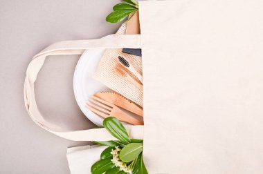 Eko kağıt sofra takımı. Yiyecek, pamuk torbası, diş fırçası, tabak, çatal, bıçak için gri arka planda bir kutu kağıt. Dünya plastikten arınmış. Geri dönüşüm konsepti çevre dostu. Yakın plan. Boşluğu kopyala.