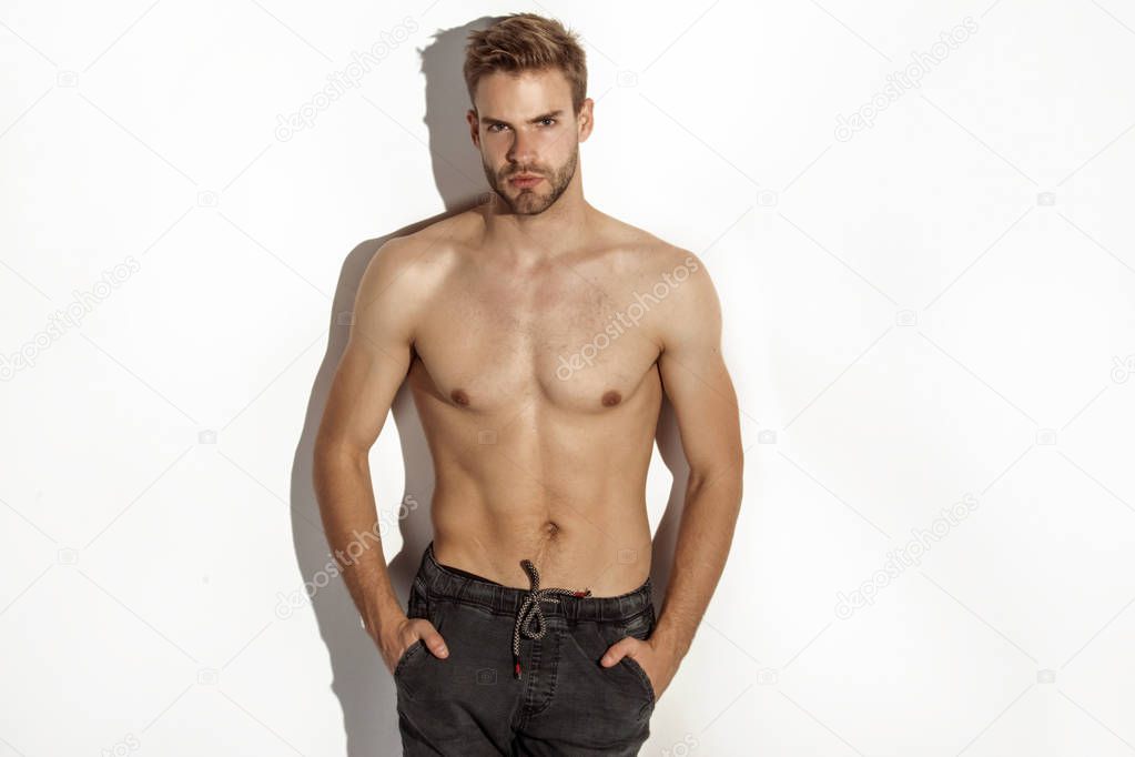 Muscle strong beautiful stripped male model in denim jeans on white isolated font background with shadow