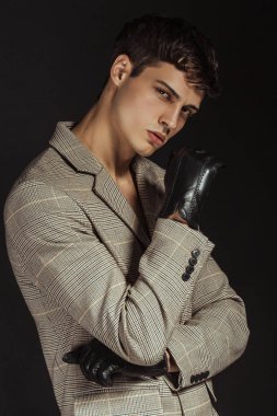 Kas gücü, siyah eldivenli ve kot pantolonlu siyah izole font arkaplanlı güzel erkek model.