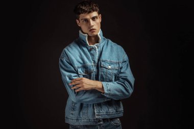 Kas gücü, beyaz kot pantolon ve kot ceketli siyah izole font arka planda beyaz tişörtlü güzel erkek manken.