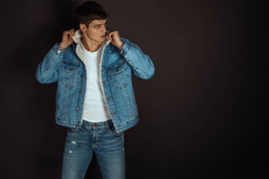 Kas gücü, beyaz kot pantolon ve kot ceketli siyah izole font arka planda beyaz tişörtlü güzel erkek manken.