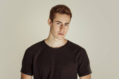 Kas gücü, kot pantolon ve siyah tişörtlü, gri izole font arka planda kemerli güzel erkek manken.