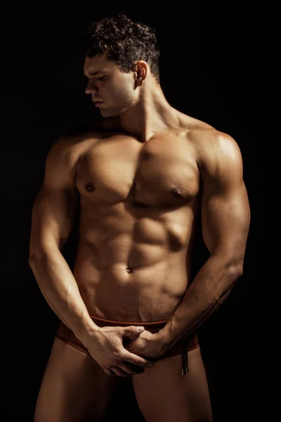 強い剥ぎ取られた筋肉水泳男性モデルで下着と水着で黒隔離されたフォントの背景 — ストック写真