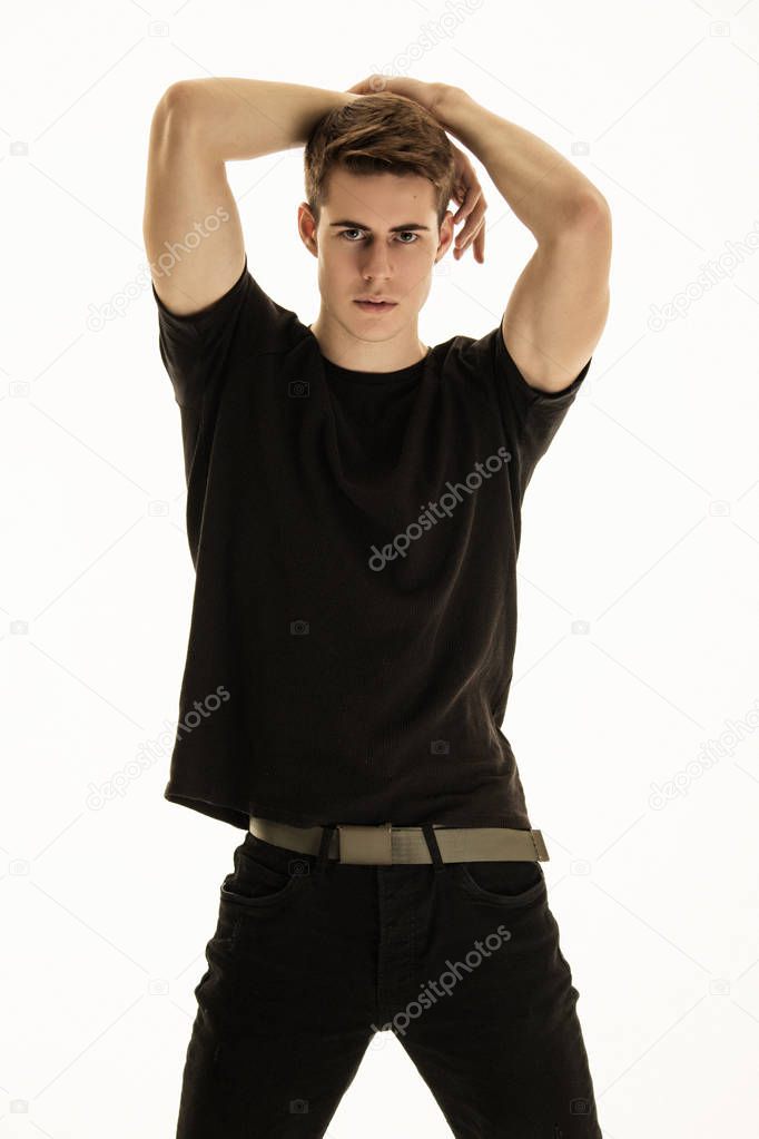 Muscle strong beautiful stripped male model in denim jeans and black t-shirt with belt on gray isolated font background