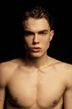 Siyah izole font arka planda siyah kot pantolon giyen güçlü, güzel erkek model.