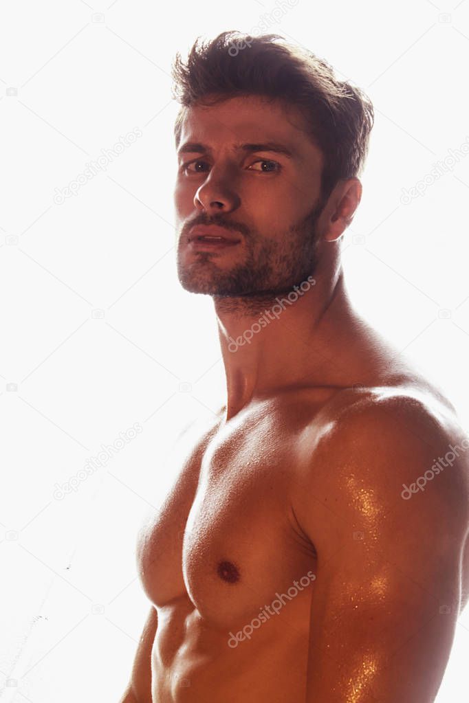 Sport sexy stripped muscle guy portrait in red light on shine isolated white font background