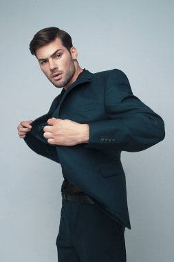 Gri izole font arka planında gölgeli duyguları olan resmi mavi takım elbiseli güçlü erkek modeller.