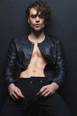 Kas gücü, kot pantolon ve siyah izole font arka planda deri ceket giyen güzel, soyulmuş erkek manken. 