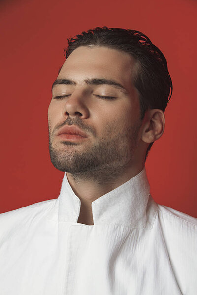 Muscle strong beautiful stripped male model in white casual suit on red isolated font background 