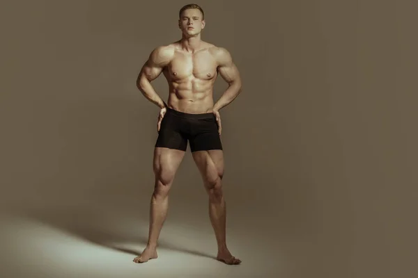 強いです裸の筋肉男性モデルで黒下着でグレー隔離されたフォントの背景 — ストック写真