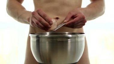 Kaslı güçlü, güzel, soyulmuş, seksi erkek model sağlıklı yemek pişirir.