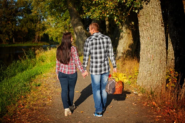 Hombre y mujer van a pasear en el picnic de otoño. Pareja caminando en un — Foto de Stock