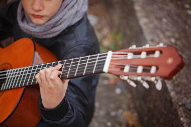 Akustik gitar yakın çekim oynayan çocuk.