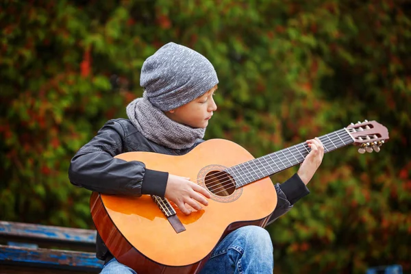 Kleiner Junge spielt Gitarre auf Naturhintergrund. Inte für Kinder — Stockfoto