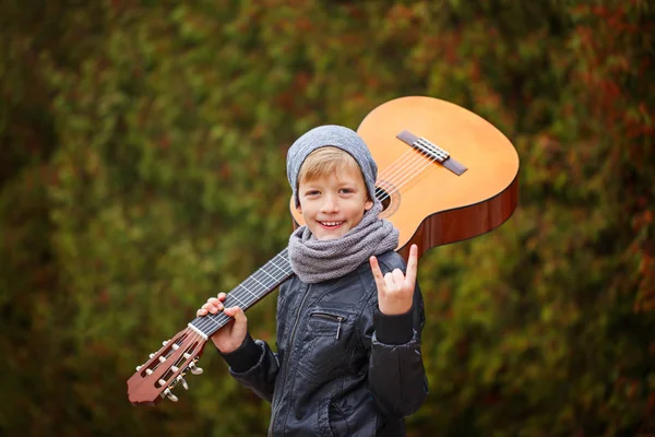 Porträt eines entzückenden Jungen mit Gitarre auf Naturhintergrund — Stockfoto