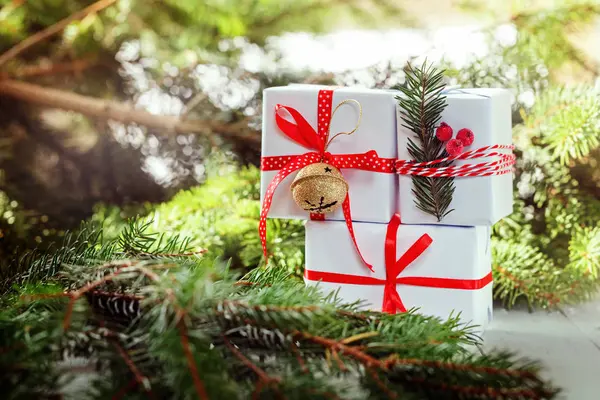 Fehér doboz díszített, piros szalag és fém Jingle Bell. Karácsonyi nyaralás dekoráció — Stock Fotó