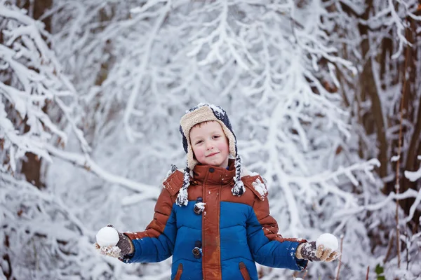 Cute little boy, kid in winter clothes walking under the snow — Stock Photo, Image