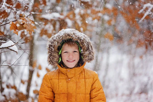 Cute little boy, kid in winter clothes walking under the snow — Stock Photo, Image