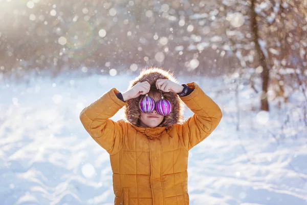Retrato de un niño con bola de Navidad caminando en la naturaleza invernal. Jugando con nieve. Concepto infancia feliz . — Foto de Stock
