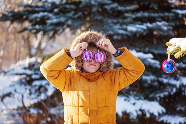 Retrato de un niño con bola de Navidad caminando en la naturaleza invernal. Jugando con nieve. Concepto infancia feliz . — Foto de Stock