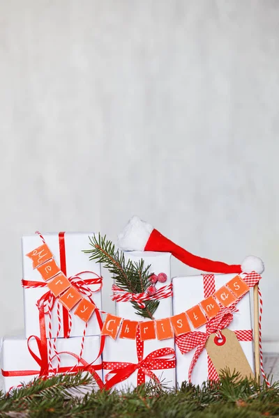 Csoport karácsonyi fehér ajándék dobozok, piros szalagok, és garland Merry . — Stock Fotó
