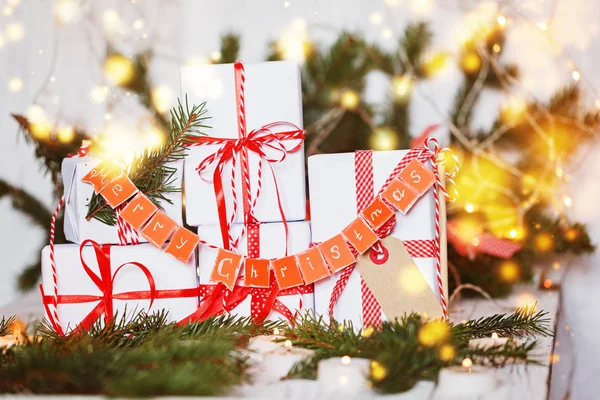 Grupo Navidad cajas de regalo blancas con cintas rojas y guirnalda Merry  . — Foto de Stock