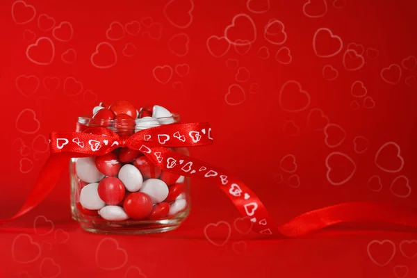 カラフルなキャンディの瓶が飾られたらに赤い弓心 — ストック写真