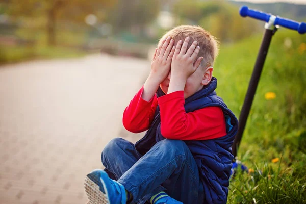 Menino chorando, caiu da scooter ao ar livre — Fotografia de Stock