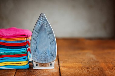 Renkli elbise ve ahşap masa evde üzerinde elektrik demir yığını