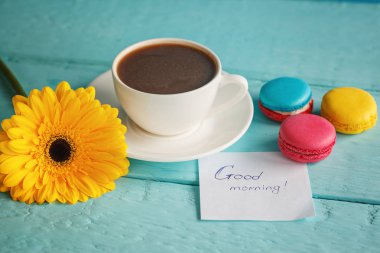 Kahve ya da çay sarı çiçek ve mavi arka plan üzerinde macaroons