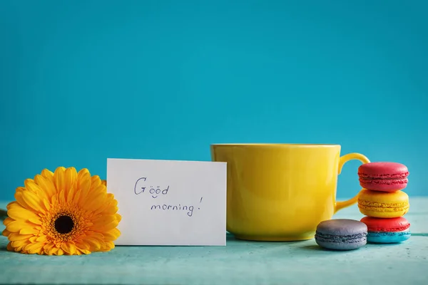 Große Tasse Tee mit weißer Blume und Makronen mit Leerzeichen auf blauem Hintergrund — Stockfoto