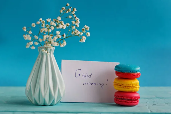 Пустая бумажная карточка с чашкой чая и вазой в цветах и макаронах на женский день — стоковое фото